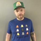 Tobias wearing a green trucker hat and a11y cats shirt
